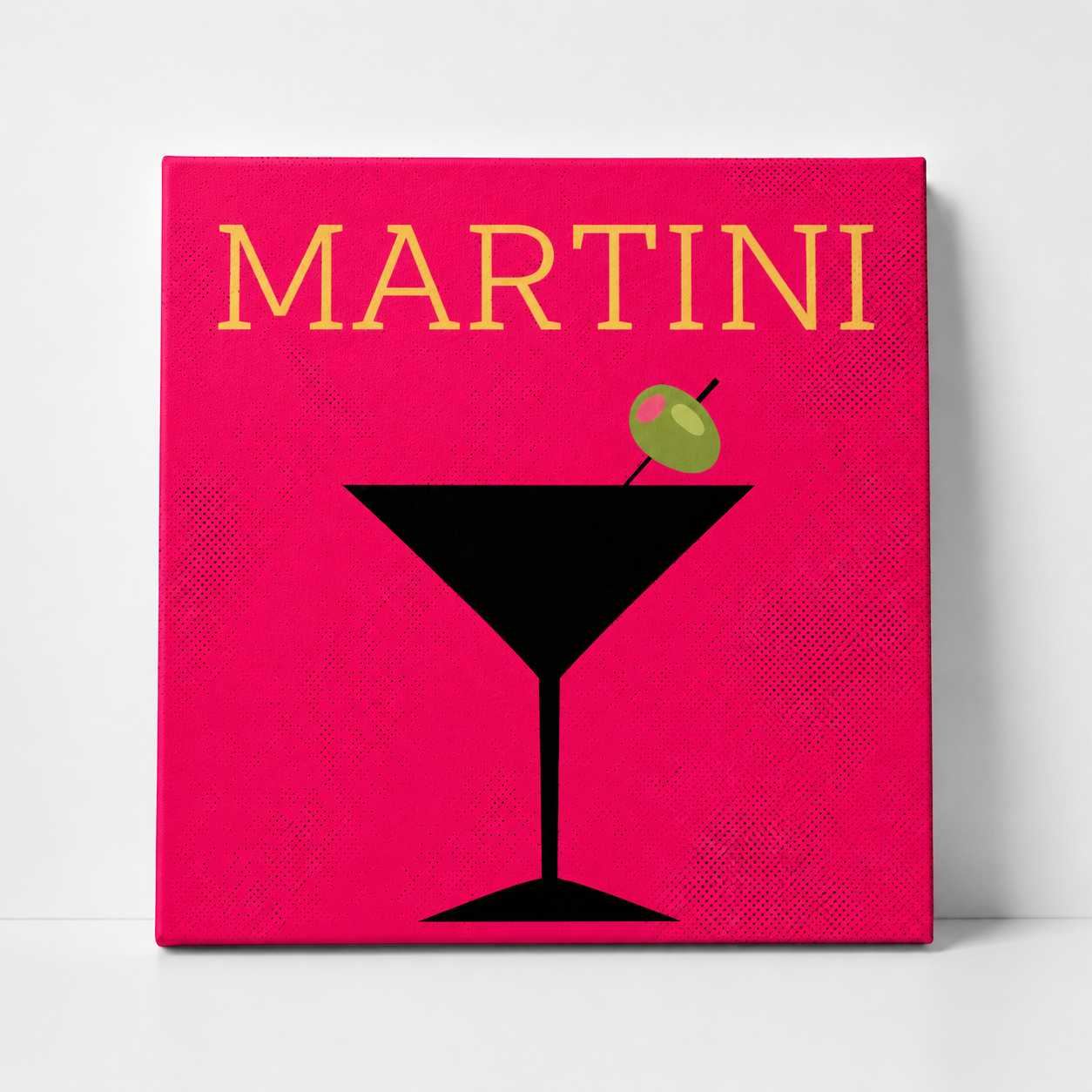 A square canvas wall art print featuring a minimalist Martini design. The background is a vibrant magenta-pink with a subtle halftone texture, displaying the word 'MARTINI' in yellow at the top and a black martini glass with a green olive garnish at the bottom.